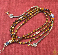 Chapelet Tibétain mala en oeil de tigre. La Magie du Bouddha.
