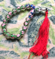 Chapelet bouddhiste de poignet en verre avec décor floral. magiedubouddha