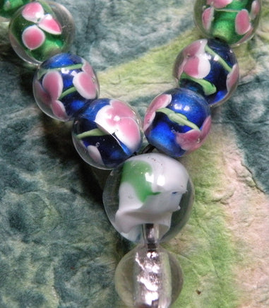 Chapelet bouddhiste de poignet en verre avec décor floral. magiedubouddha