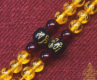 Chapelet tibétain mala en perles de verre jaune à mantra de Chenrezi et perle sacrée Ye Ming Zhu La Magie du Bouddha.