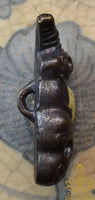 Amulette Phra Ngang assis sur un crâne en alliage alchimique mekkapat