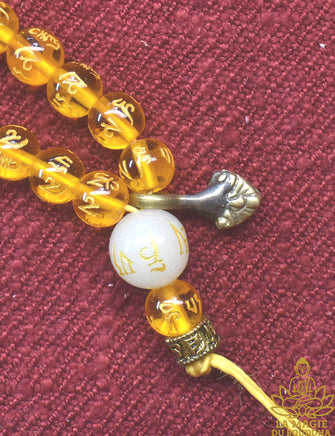 Chapelet tibétain mala en perles de verre jaune à mantra de Chenrezi et perle sacrée Ye Ming Zhu La Magie du Bouddha.
