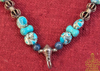 Collier rituel pour amulette en perles turquoise, lapis-lazuli, dorje et grelots – Pièce unique La Magie du Bouddha.