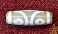 Amulette tibétaine perle Dzi trois yeux en agate translucide beige La Magie du Bouddha.
