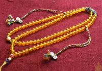 Chapelet Tibétain Mala – Perles mantra de Chenrezi en verre jaune La Magie du Bouddha.