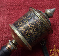 Moulin à prières tibétain artisanal en cuivre et laiton La Magie du Bouddha.