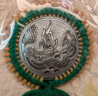 Traditional Thai good luck charm engraved with a Naga and grains of rice