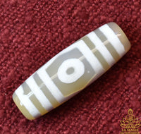 Amulette tibétaine perle Dzi trois yeux en agate translucide beige La Magie du Bouddha.