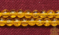 Chapelet tibétain mala en perles de verre jaune à mantra de Chenrezi et perle sacrée Ye Ming Zhu La Magie du Bouddha.