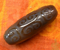 Perle tibétaine en agate sculptée à motifs sacrés La Magie du Bouddha.