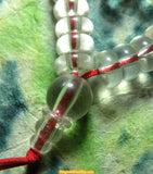 Mala en perles de verre plates translucides.